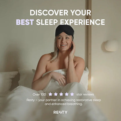 A blonde woman sitting up in bed wearing a black resty sleepmask. Text overlaying image reads ' Discover your best sleep experience. Over 100 5 star reviews. Resty- your partneer in achieving restorative sleep and enhanced breathing.'