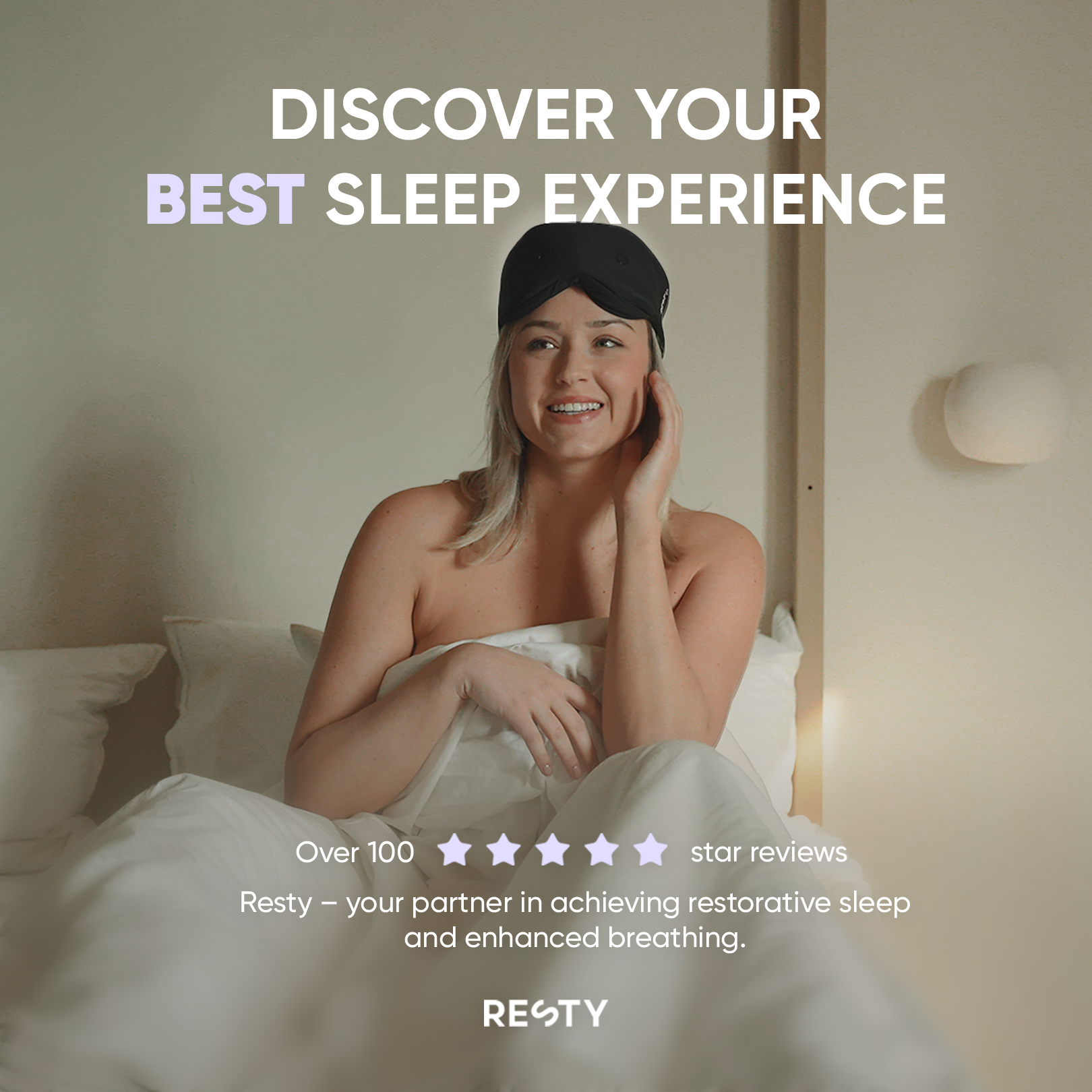 A woman sitting up in bed is wearing a resty sleepmask on her head The text overlaying the image reads 'Discover your best sleep experience. Over 100 5 star reviews. Resty- your partner in achieving restorative sleep and enhanced breathing.